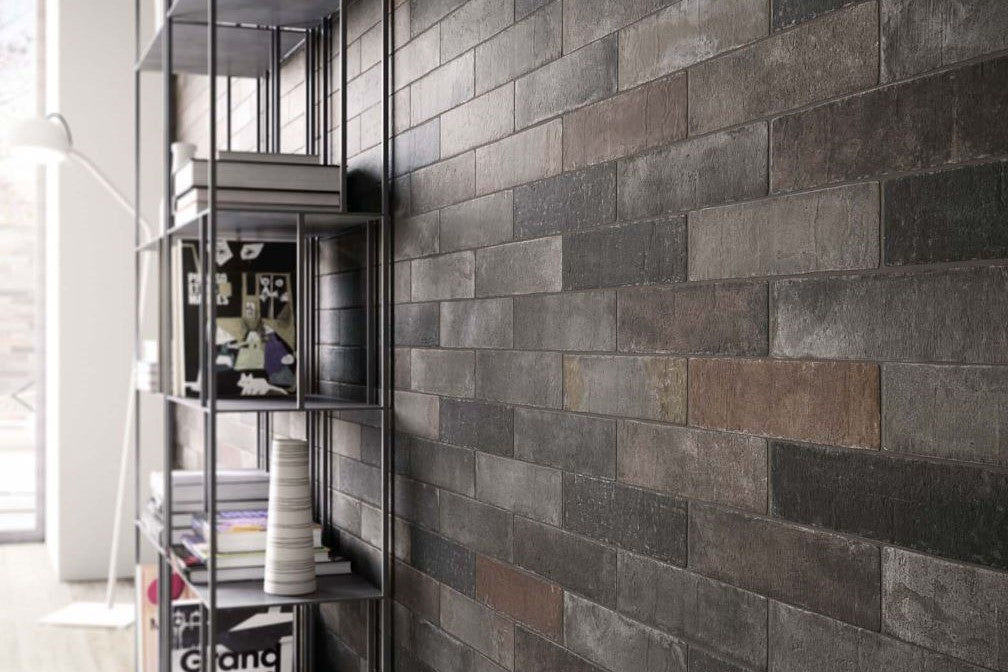 Gray brick-patterned wall with a metal shelf against a window. Modern living with Marazzi Terramix 70x280 brick looks wall and floor tiles. Melbourne, Geelong, Shepparton, Ballarat, Bendigo, Horsham, Warrnambool, Mornington, Bellarine, Peninsula tiles. Victoria and Nationwide Delivery. Australia.