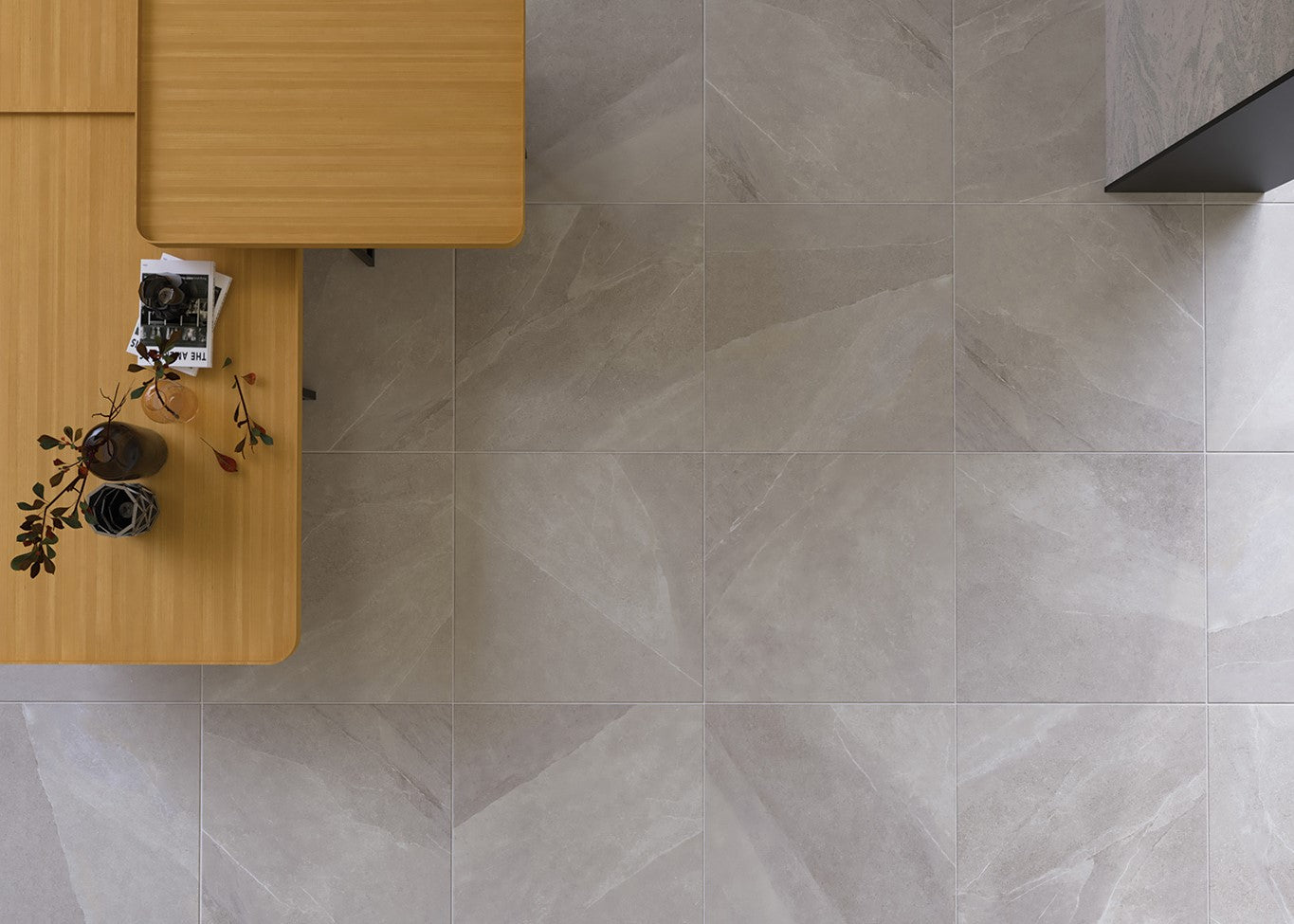 Gray tiled floor with a wooden table and plant in the corner. Modern bathroom and living with 600x600 Pietra Stone Look Matt Tiles. Melbourne, Geelong, Shepparton, Ballarat, Bendigo, Mornington, Bellarine, Peninsula, Melton, Lara, Sunbury, Warrnambool, Horsham tiles. Victoria and Nationwide Delivery. Australia.