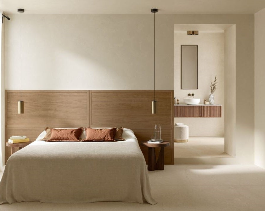 Modern bedroom with wooden headboard and bathroom in the background. Modern bathroom and living with 600x600 Pietra Di Sicilia Stone Look Matt Tiles by Marazzi. Melbourne, Geelong, Shepparton, Ballarat, Bendigo, Mornington, Bellarine, Peninsula, Melton, Lara, Sunbury, Warrnambool, Horsham tiles. Victoria and Nationwide Delivery. Australia.
